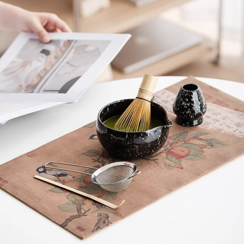 Bamboo scoop next to a matcha bowl and whisk